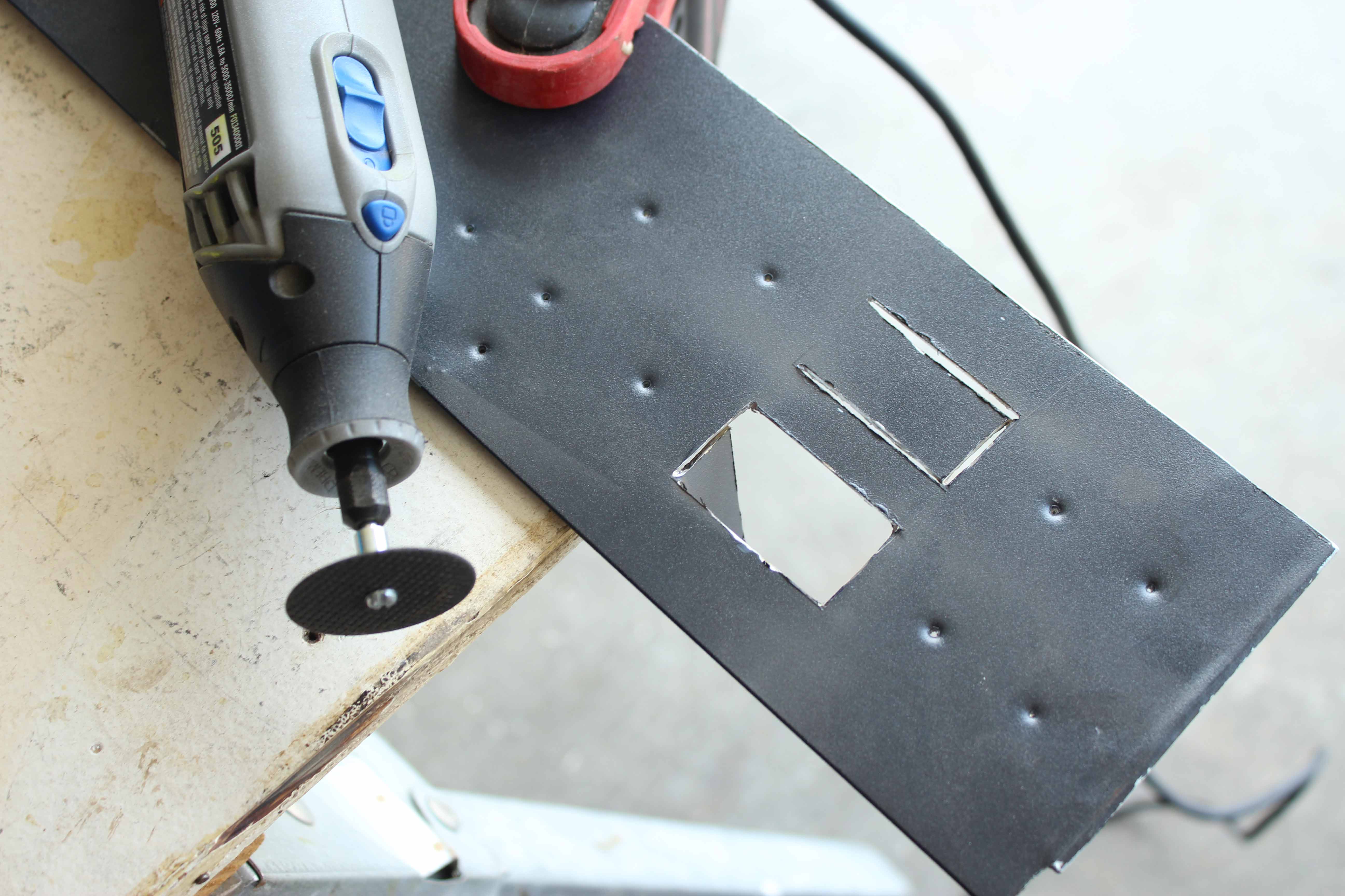 Using a dremel to cut the square holes for manufacturing an ATX power supply